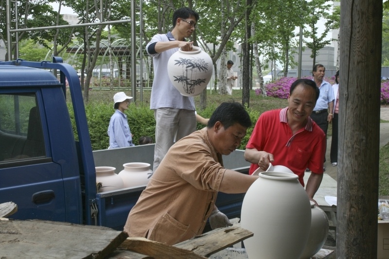 Unloading the pots from truck to dip them in slip and add them to the kiln.