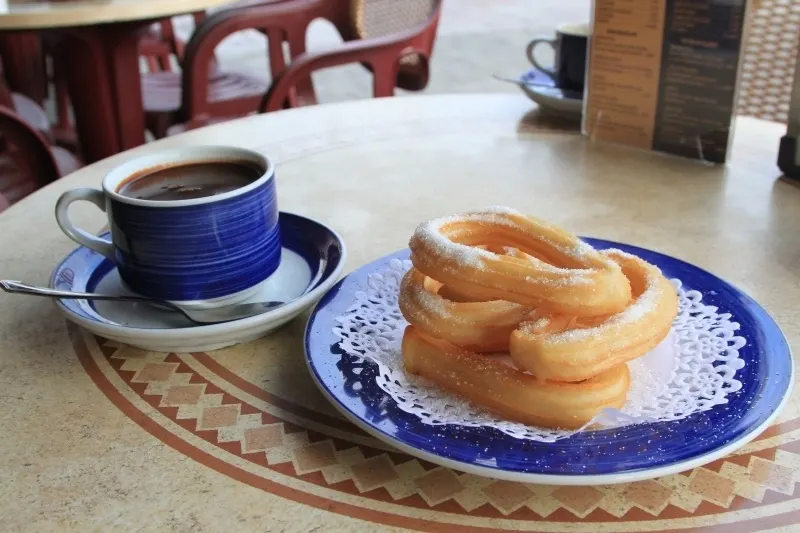 Churros y Chocolate in an outdoor cafe in Llanes.