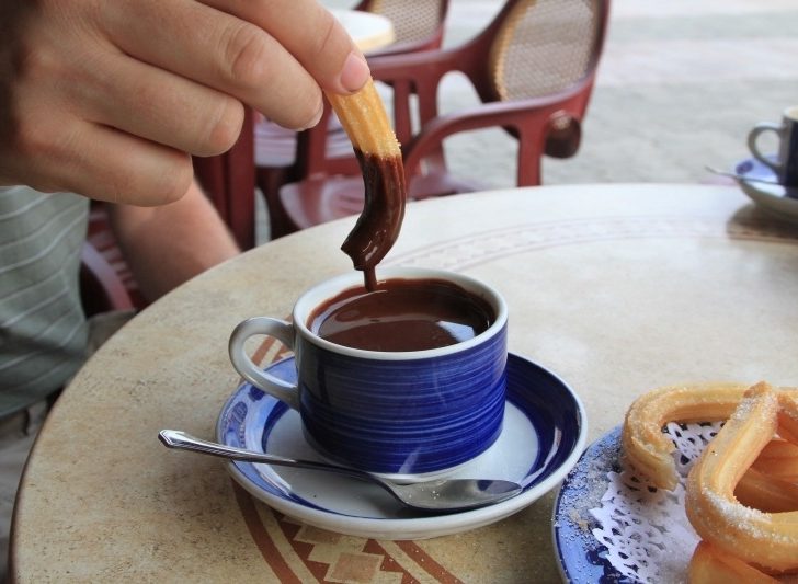 Eating Churros y chocolate, the national snack of Spain.