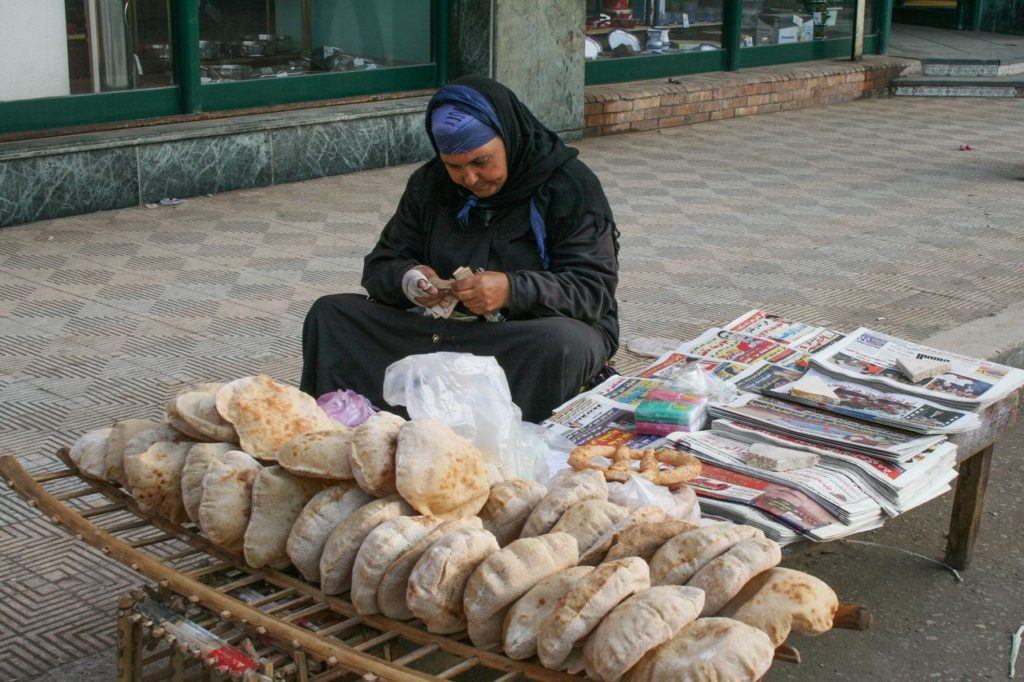 Bread and newspaper vendor selling early morning in Cairo.