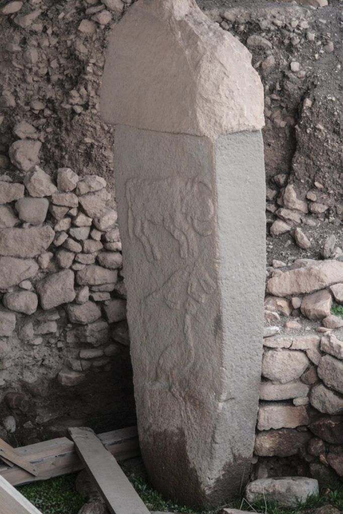 Gobekli Tepe standing stone with bull, fox, and nird carvings.