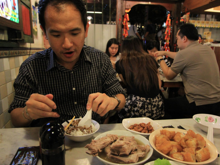 Our friend is showing us how to eat traditional Bak Kut Teh in Singapore.