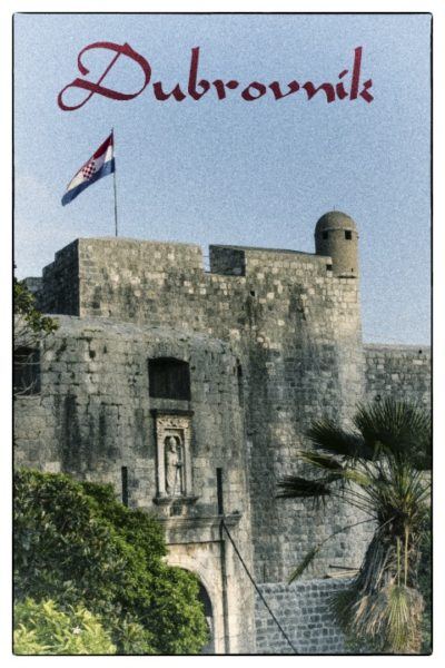 Dubrovnik city gate with Croatia flag flying on tower.
