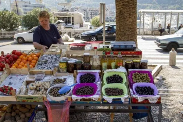Market scene with woman selling olives and dried fruits.