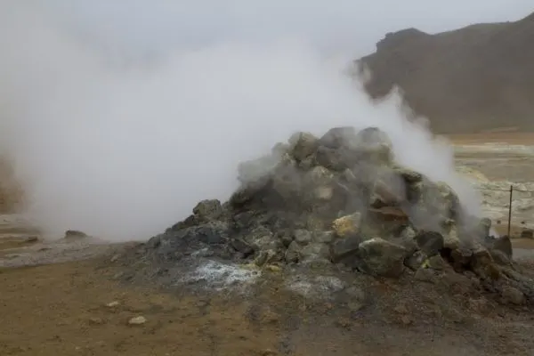 A standard example of a fumerole releasing hot steam and gases from deep within the earth.