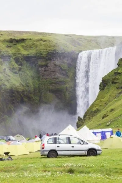 A small free campground near an Icelandic waterfall.