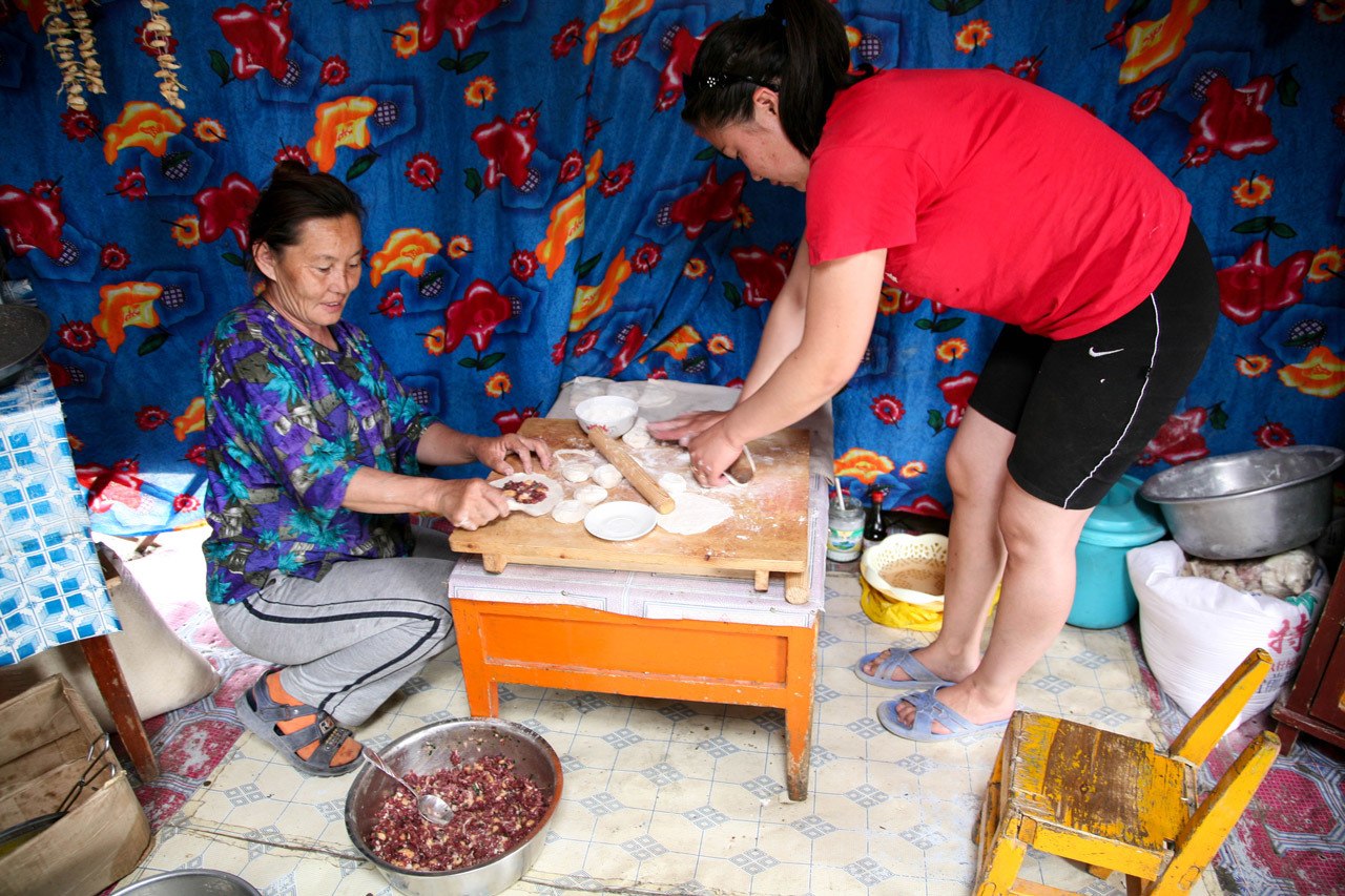 Two women making traditional Khuushuur in a ger restaurant.