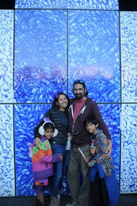 Family in front of blue wall.