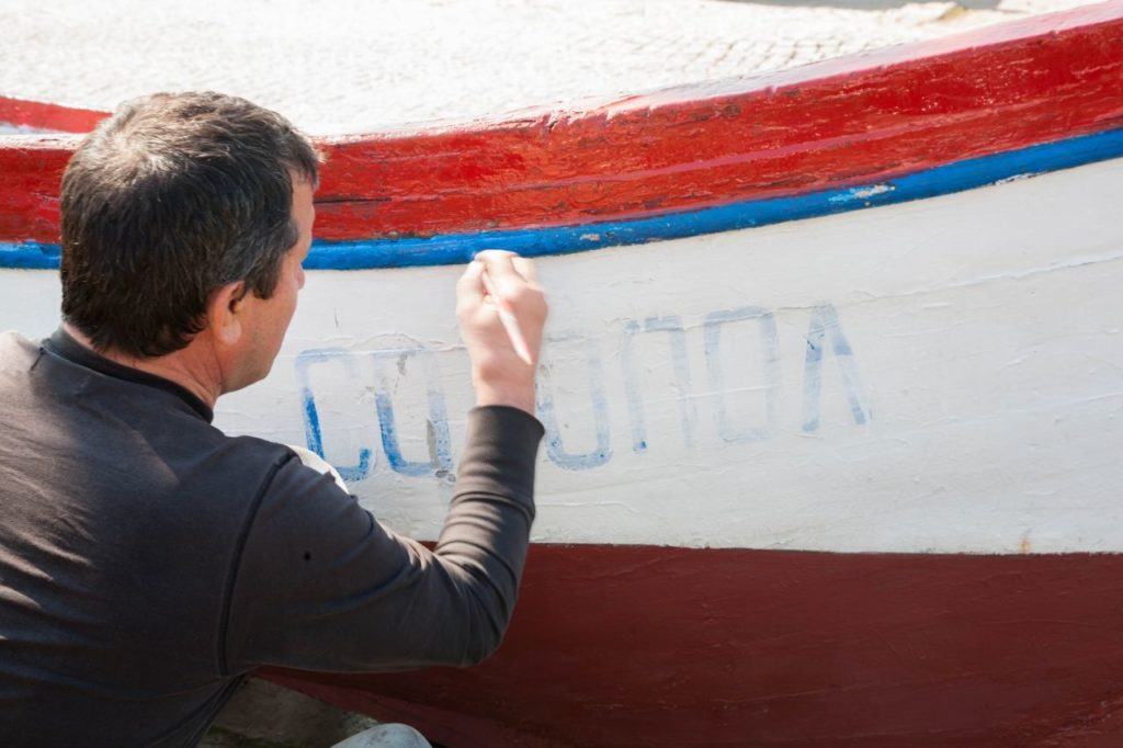 Man painting a boat. 