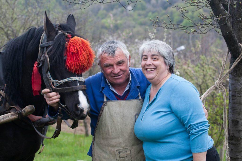 Corinne standing with a local man and his horse during a visit to Bulgaria. 