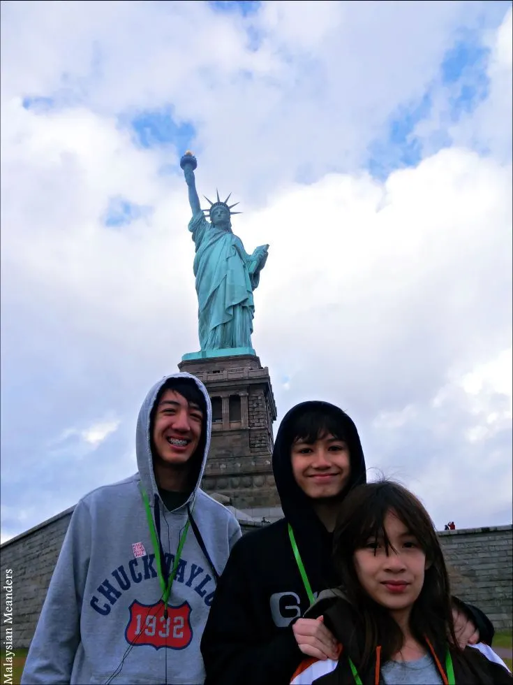 The family in front of the Statue of Liberty.
