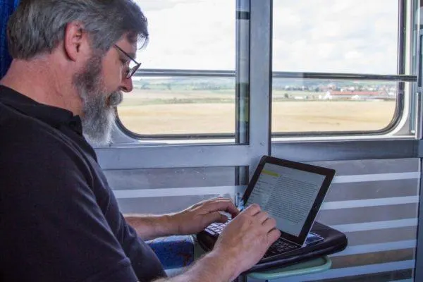 Jim working on his ipad while enjoying train travel in Eastern Europe. 
