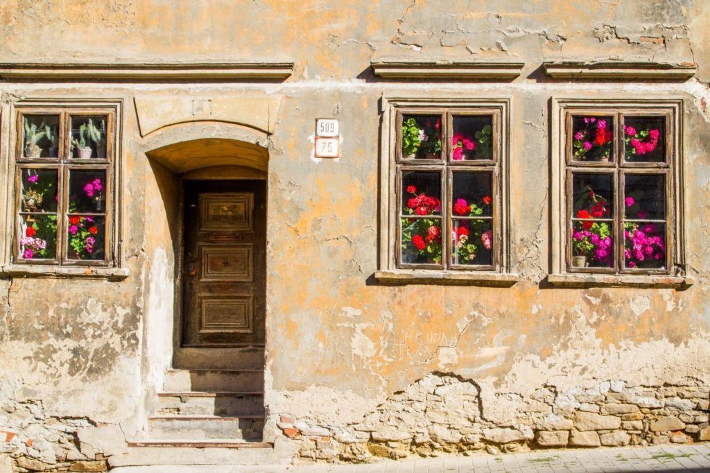 Picturesque stone building face with flowers in the windows.