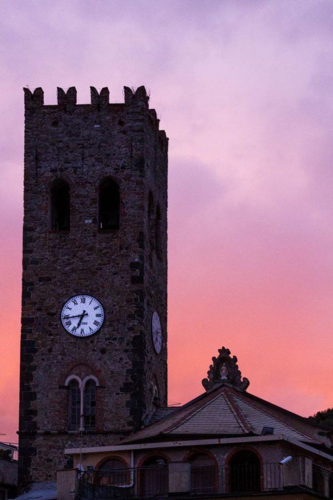 Sunset behind a medieval Cinque Terre clock tower.