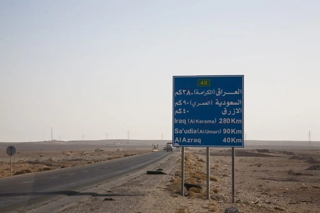 Jordanian highway sign with distances to Iraq and Al Azraq.
