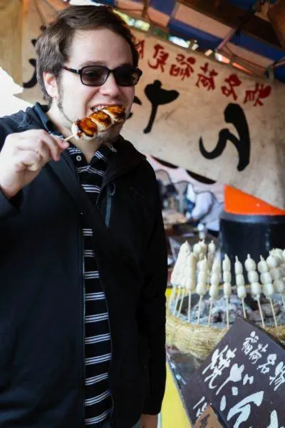 Michael eating mochi from a Japanese food stall