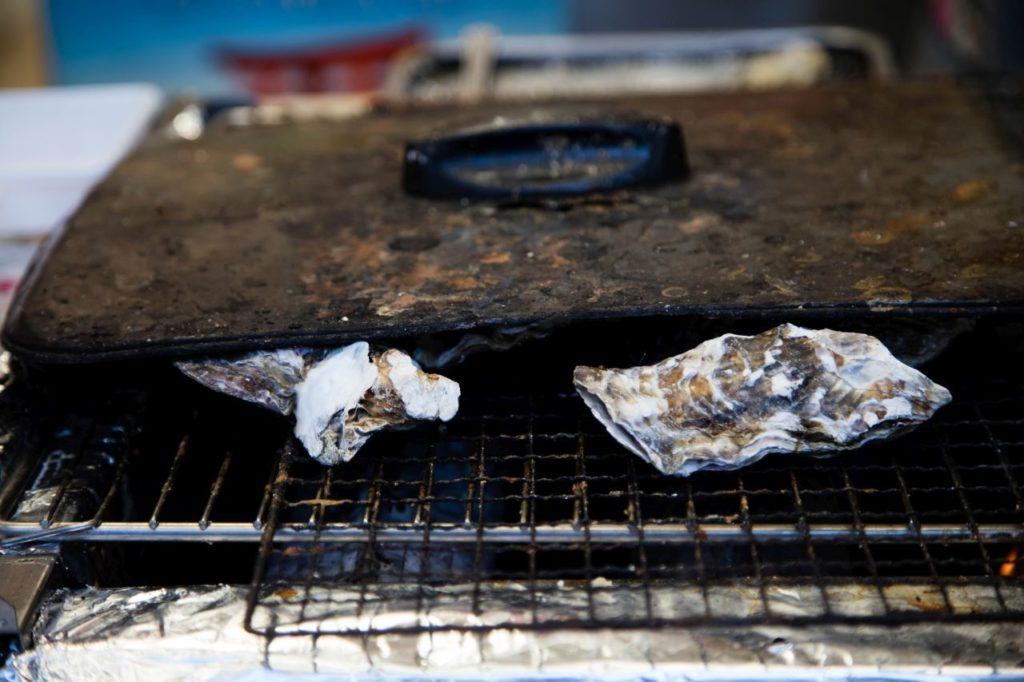 2 oysters being grilled, Make sure to add oysters to your Japan food guide. 