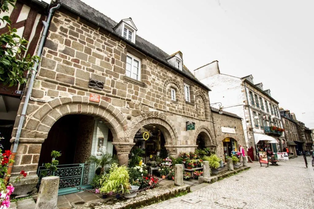 Old stone house on cobblestone pedestrian street in Brittany, France.