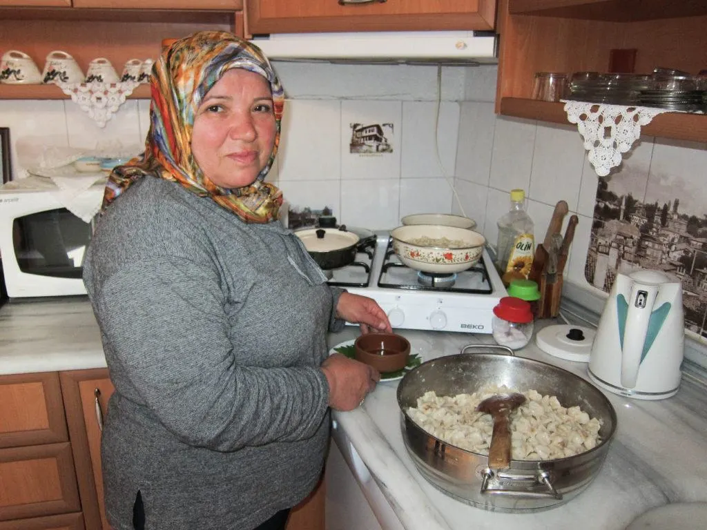 Woman preparing manti, Turkish dumplings.