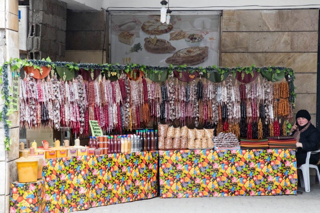 Roadside churchkhela stand with several variations of the fruit and nut snack on display.