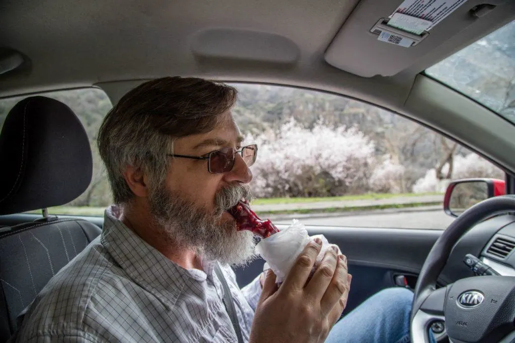 Jim takes a bite of churchkhela for the road.