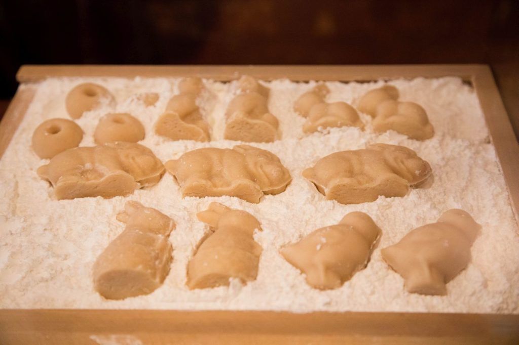 Marzipan figures drying out in cornstarch before they are painted and sold.