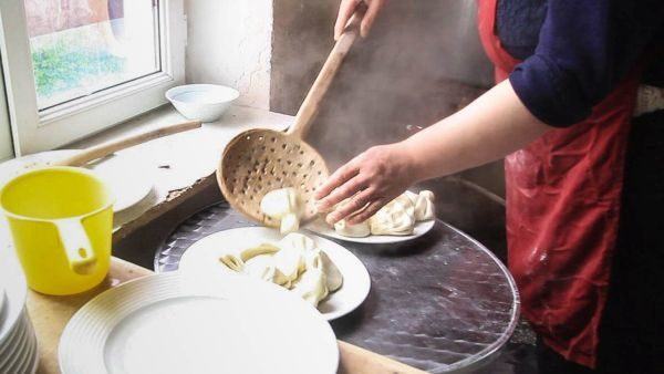 Large wooden straining spoon for scooping khinkali out of the hot water pot.