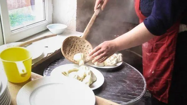 Large wooden straining spoon for scooping khinkali out of the hot water pot.