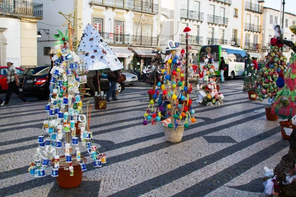 Christmas trees made out of recycled items on display in a Portuguese street.
