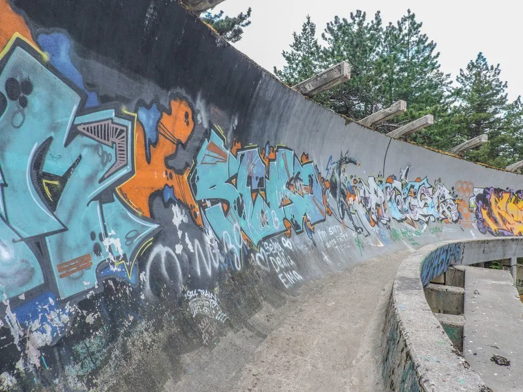 Abandoned bobsled track in Sarajevo covered in graffiti.