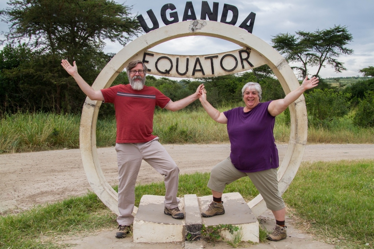 Happy travelers posing in front of the Uganda Equator Marker.