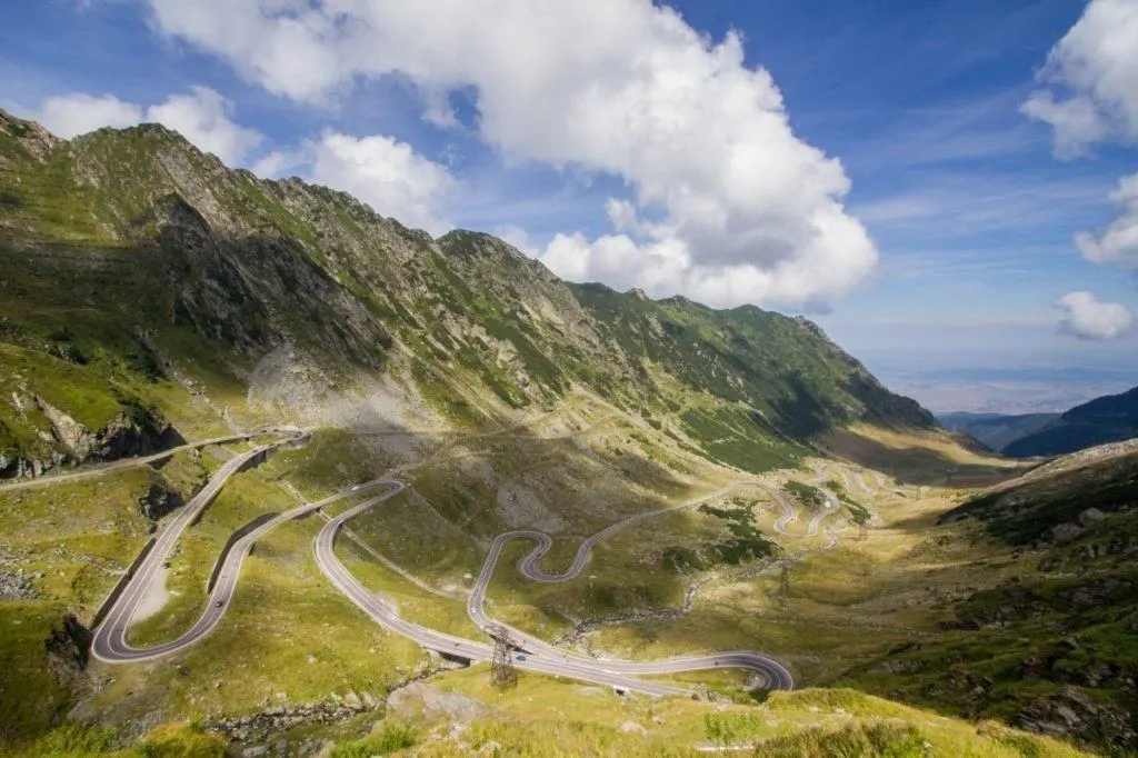 Transfagarasan Highway in Romania winds down the mountain valley with multiple hairpin curves.