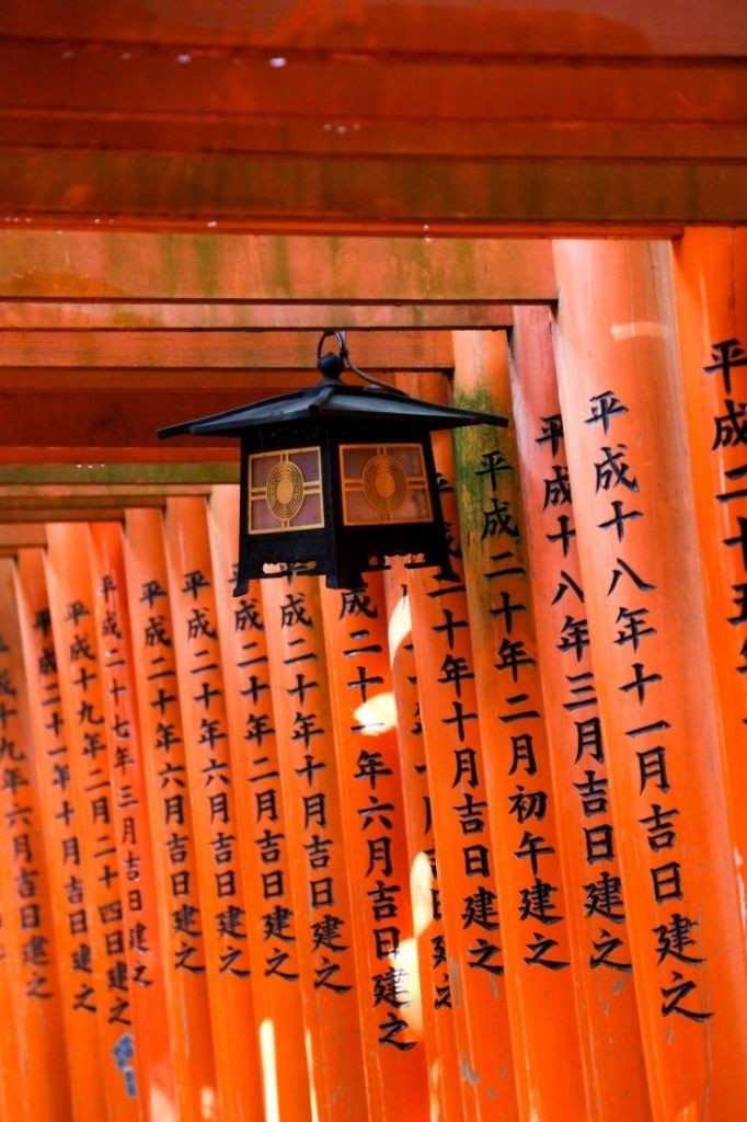 A lantern hangs inside the Torii gates on the path at Fushimi Inari Shrine in Kyoto.