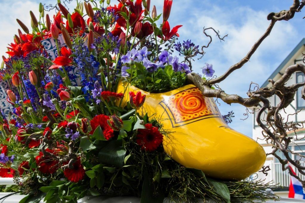 Giant wooden shoe with bouquet of tulips and other flowers.