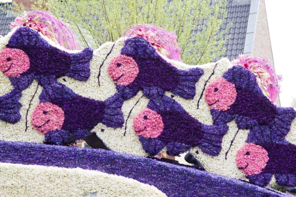 A purple and white fish and dove float modeled after the art of Escher at the Tulip Festival Parade in the Netherlands.