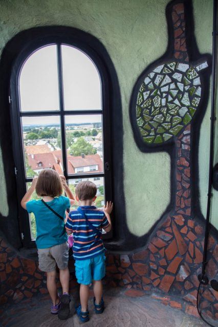 2 children gaze out of a window of the Kuchlbauer Tower.