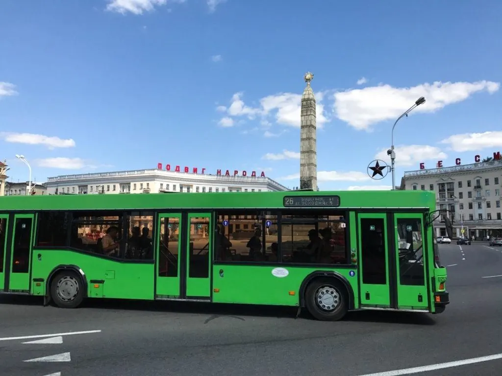 A green city transit bus drives around Minsk.