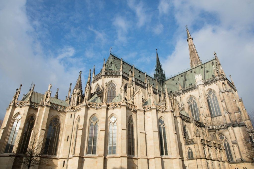 Alter Dom exterior with blue sky and clouds.