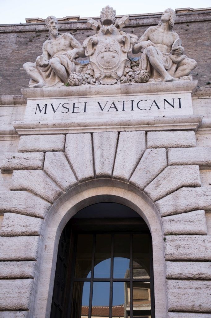 Door and Entry to Vatican City Museum with Latin inscription and a decorated mantel.