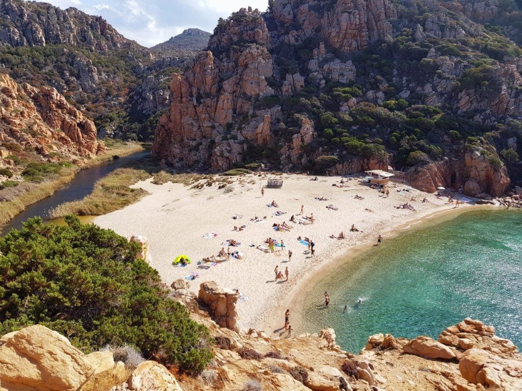 A beach with people in Sardinia.