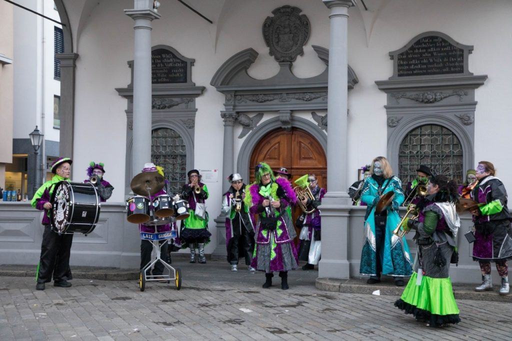 A colorful, costumed band play in the village square.
