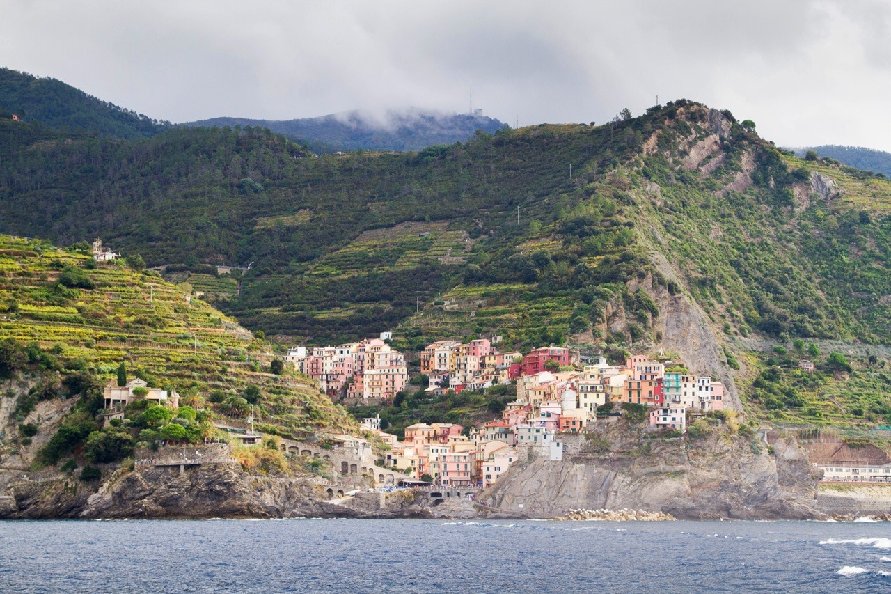 Taking a ferry past one of the five towns in Cinque Terre, Italy