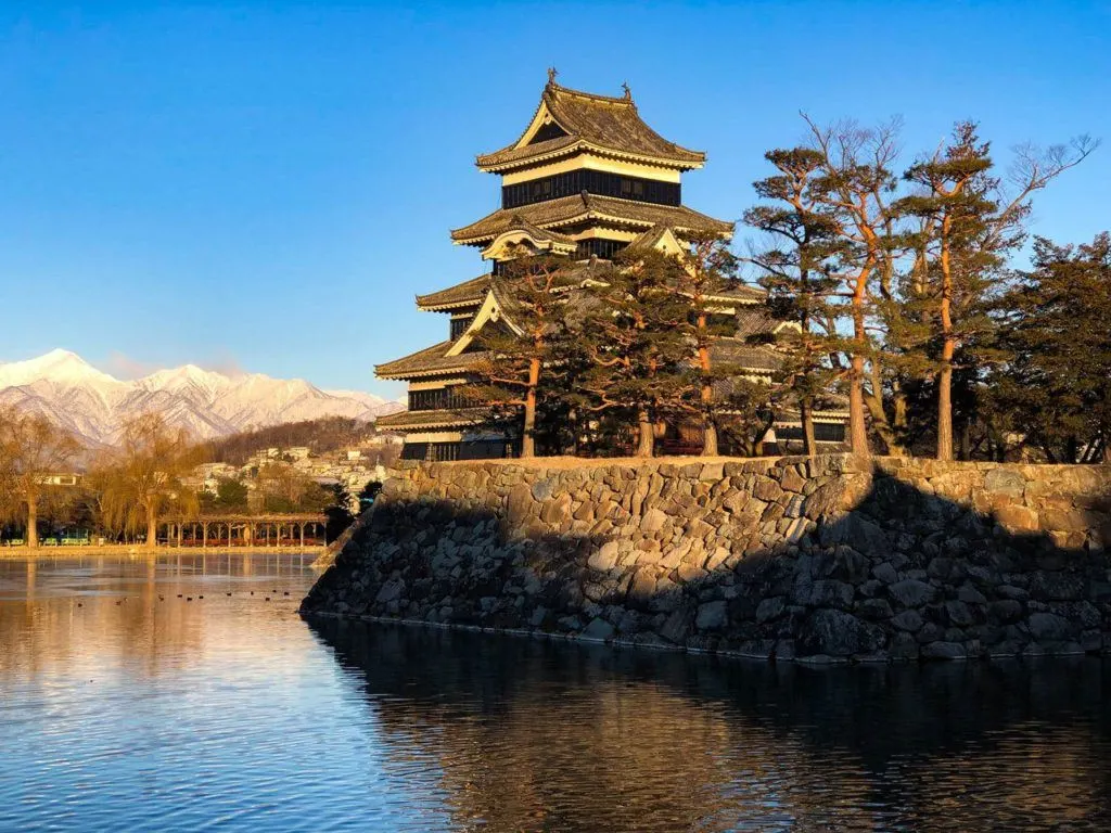 Matsumoto Castle with snow on Japanese Alps in background, a fantastic Japan winter destination.