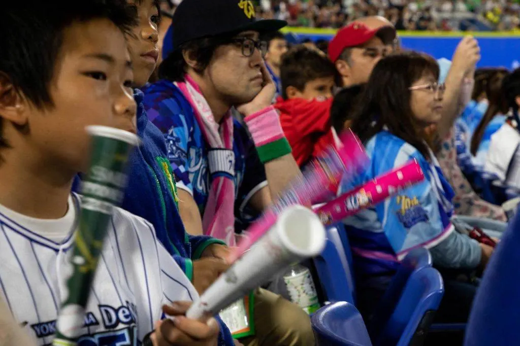 Fans clap together mini-baseball bats to cheer on their players and team.