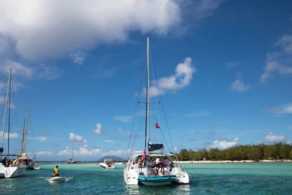 Catamaran and other boats parked near day trip island in Mauritius.