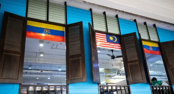 Interior of Central Market, windows of the food court on 2nd floor with Malaysian flags.