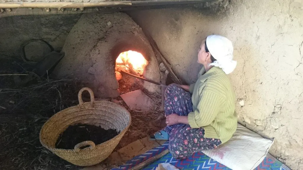 A woman tends bread in a traditional clay oven at the Berber Cultural Center in Marrakesh, Morocco.