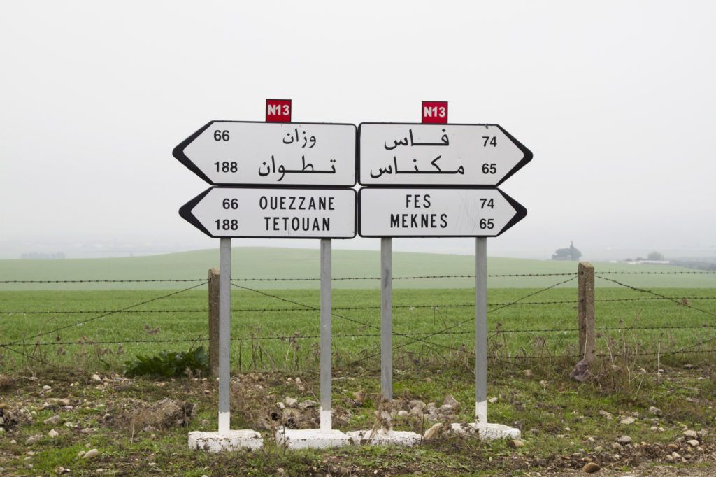 A set of directional signs telling us which way to go in Arabic and in English.