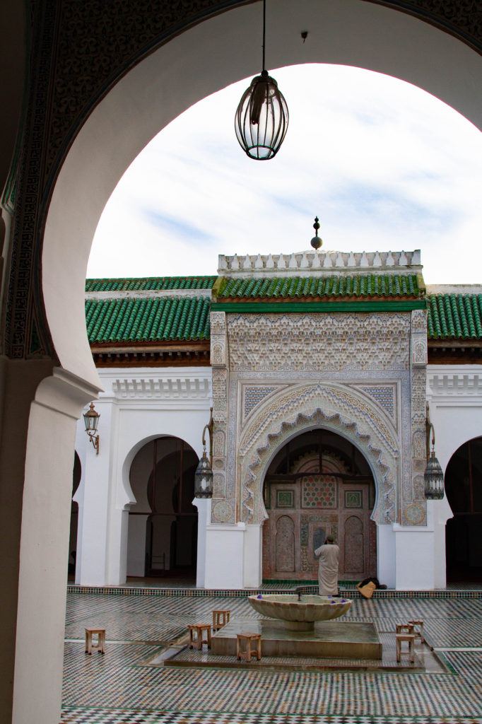 A silent glimpse into a madrasa in Fez, with its arch and tiles.