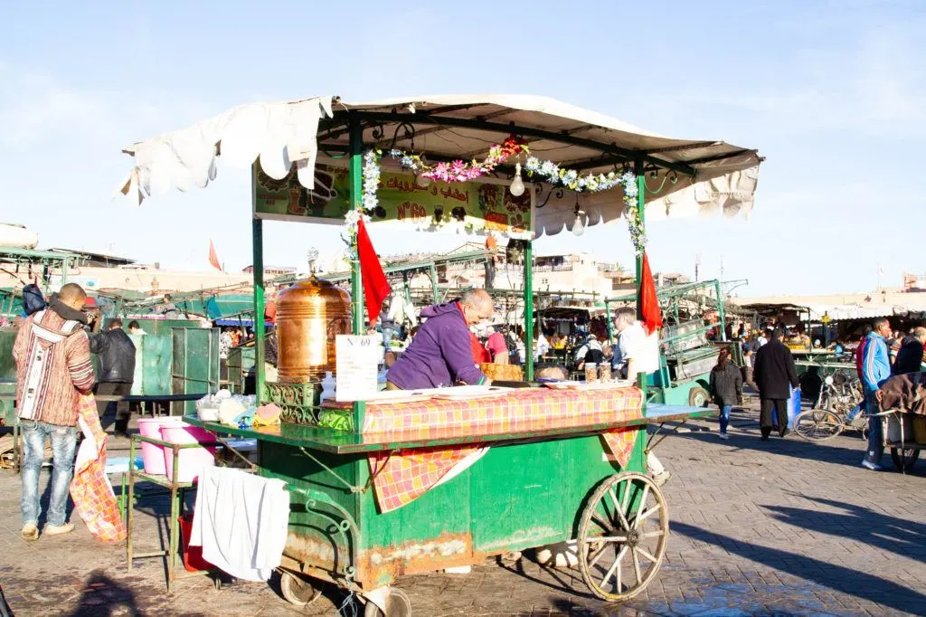 A green food cart is setup and ready to serve tea and sweets in Jemaa el Fna, the main square in Marrakesh.